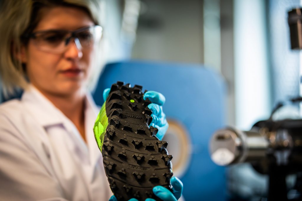 female scientist inspecting a hiking shoe in a lab